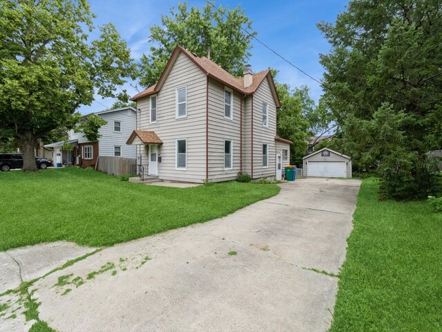 700 W Boston Ave, Indianola, IA 50125 - view of front of house featuring an outbuilding, a chimney, a front yard, and a detached garage