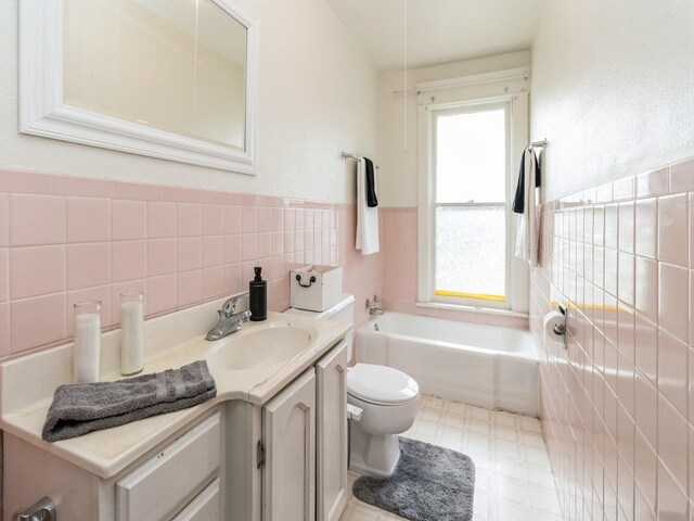 700 W Boston Ave, Indianola, IA 50125 - bathroom featuring tile walls, a bath, vanity, tile patterned floors, and a wainscoted wall