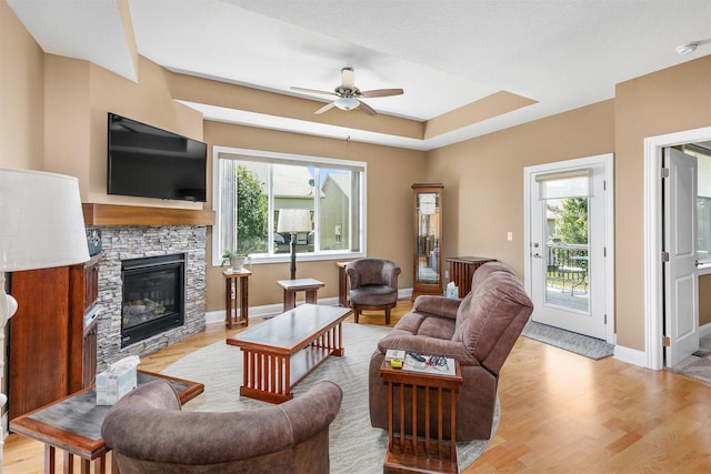 1592 SE Blackthorne Dr, Waukee, IA 50263 - living room with healthy amount of natural light, ceiling fan, light wood-style flooring, and a stone fireplace
