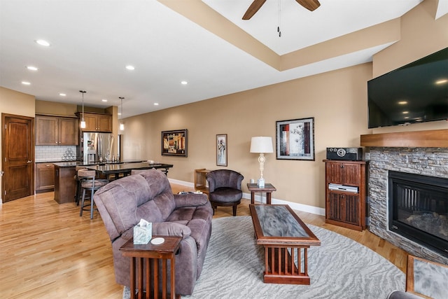 1592 SE Blackthorne Dr, Waukee, IA 50263 - living area with light wood-style floors, a fireplace, ceiling fan, and recessed lighting