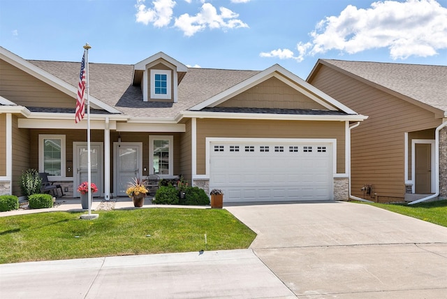 1592 SE Blackthorne Dr, Waukee, IA 50263 - view of front of home with a front yard, an attached garage, driveway, stone siding, and roof with shingles