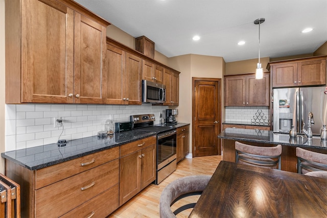 1592 SE Blackthorne Dr, Waukee, IA 50263 - kitchen with appliances with stainless steel finishes, decorative backsplash, light wood-type flooring, brown cabinets, and recessed lighting