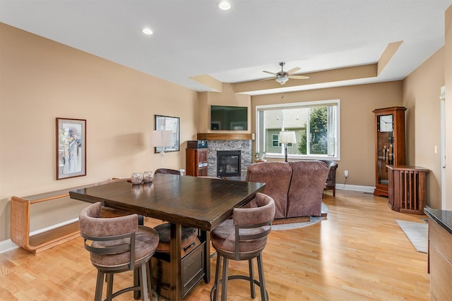 1592 SE Blackthorne Dr, Waukee, IA 50263 - dining space with a stone fireplace, light wood-style floors, a ceiling fan, and recessed lighting