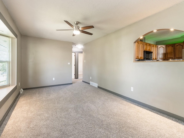 4518 SE 6th St, Des Moines, IA 50315 - unfurnished room featuring a ceiling fan, light colored carpet, and arched walkways