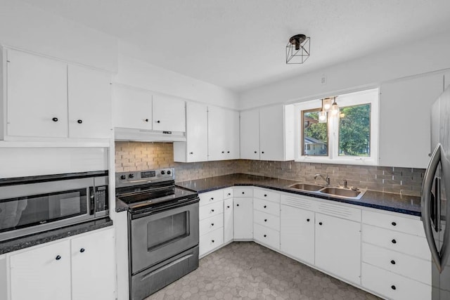 3017 Lincoln Way, Ames, IA 50014 - kitchen featuring stainless steel appliances, under cabinet range hood, backsplash, and dark countertops