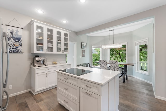 3124 Greenwood Rd, Ames, IA 50014 - kitchen with black electric stovetop, wood-type flooring, light countertops, freestanding refrigerator, and glass insert cabinets