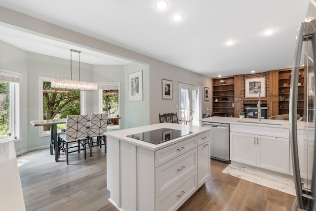 3124 Greenwood Rd, Ames, IA 50014 - kitchen featuring black electric stovetop, dishwasher, light wood finished floors, white cabinetry, and recessed lighting