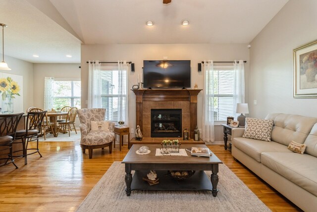1921 Bristol St, Norwalk, IA 50211 - living room with wood finished floors, a tiled fireplace, vaulted ceiling, and recessed lighting
