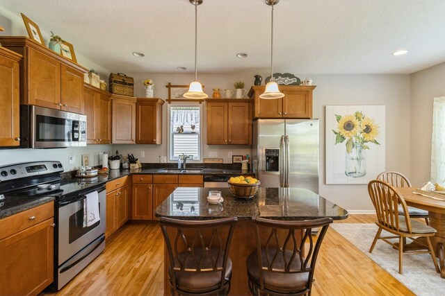 1921 Bristol St, Norwalk, IA 50211 - kitchen featuring appliances with stainless steel finishes, light wood finished floors, brown cabinets, and recessed lighting