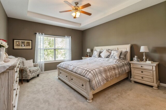 1921 Bristol St, Norwalk, IA 50211 - bedroom with light carpet, a tray ceiling, and a ceiling fan