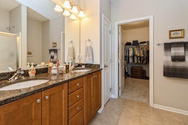 1921 Bristol St, Norwalk, IA 50211 - full bath with double vanity, a shower stall, a spacious closet, and tile patterned flooring