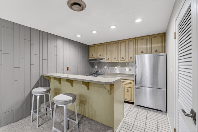 4130 Beaver Ave, Des Moines, IA 50310 - kitchen featuring freestanding refrigerator, a breakfast bar area, recessed lighting, light countertops, and light tile patterned floors