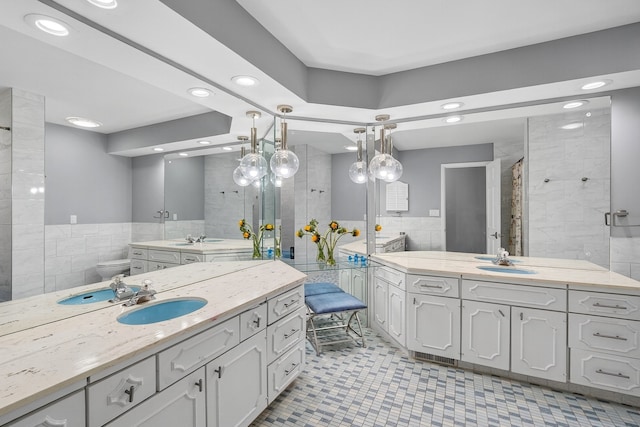 4130 Beaver Ave, Des Moines, IA 50310 - bathroom with tile walls, two vanities, recessed lighting, a shower stall, and a wainscoted wall