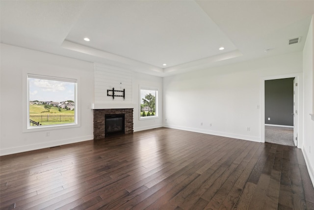 1824 Bentley Ct, Norwalk, IA 50211 - unfurnished living room featuring a tray ceiling, healthy amount of natural light, dark wood-style flooring, and recessed lighting
