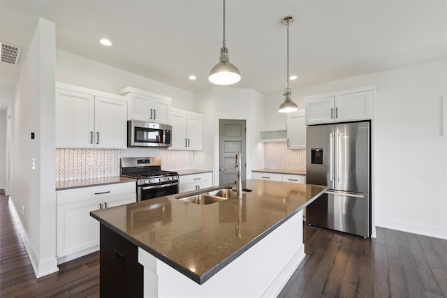 1824 Bentley Ct, Norwalk, IA 50211 - kitchen with stainless steel appliances, dark wood-style flooring, a center island with sink, tasteful backsplash, and white cabinets