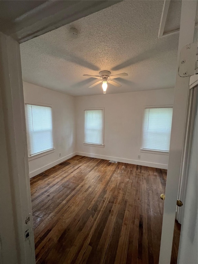3618 Dubuque Ave, Des Moines, IA 50317 - unfurnished room featuring a textured ceiling, dark wood-type flooring, a smoke detector, and ceiling fan