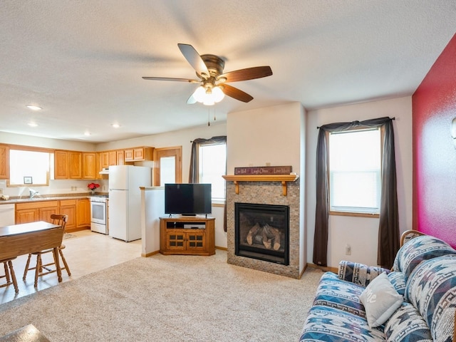 815 W 6th St S, Newton, IA 50208 - living area featuring a textured ceiling, a fireplace, a ceiling fan, and recessed lighting