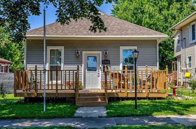 1718 Otley Ave, Perry, IA 50220 - view of front of property featuring roof with shingles, a front yard, and a wooden deck