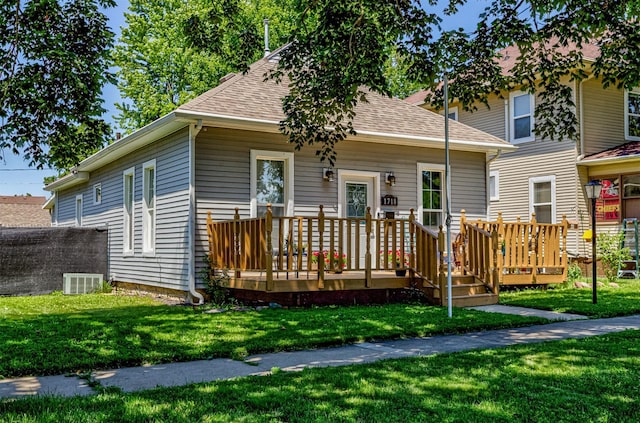 1718 Otley Ave, Perry, IA 50220 - view of front of property featuring a wooden deck, a front lawn, and a shingled roof