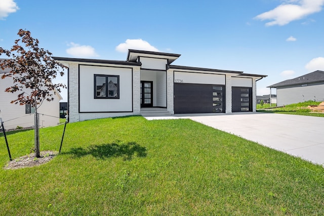 17736 Hammontree Dr, Clive, IA 50325 - contemporary house featuring concrete driveway, a garage, a front lawn, and brick siding