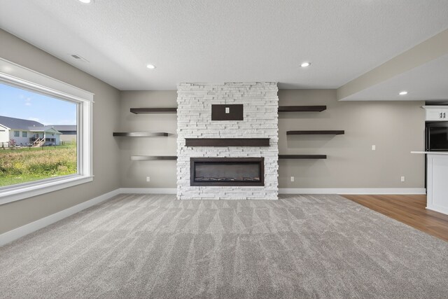 17736 Hammontree Dr, Clive, IA 50325 - unfurnished living room featuring carpet floors, a fireplace, a textured ceiling, and recessed lighting