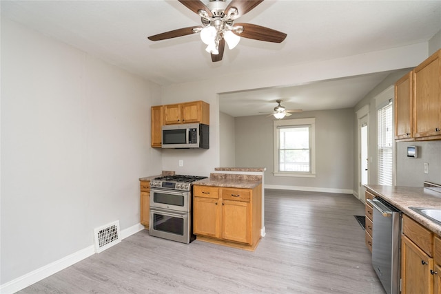 2124 E 23rd St, Des Moines, IA 50317 - kitchen with stainless steel appliances, a ceiling fan, and light wood-style flooring