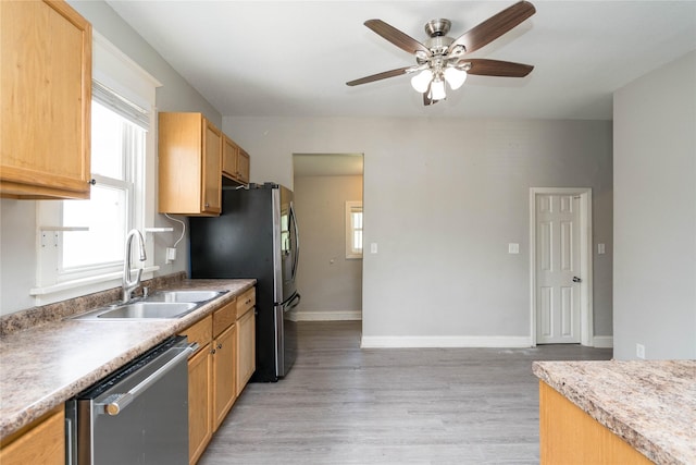 2124 E 23rd St, Des Moines, IA 50317 - kitchen with stainless steel appliances, ceiling fan, light wood-style floors, and plenty of natural light