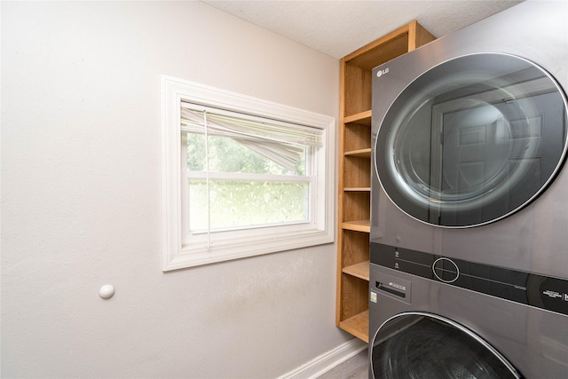 2124 E 23rd St, Des Moines, IA 50317 - laundry area featuring stacked washer and clothes dryer and baseboards
