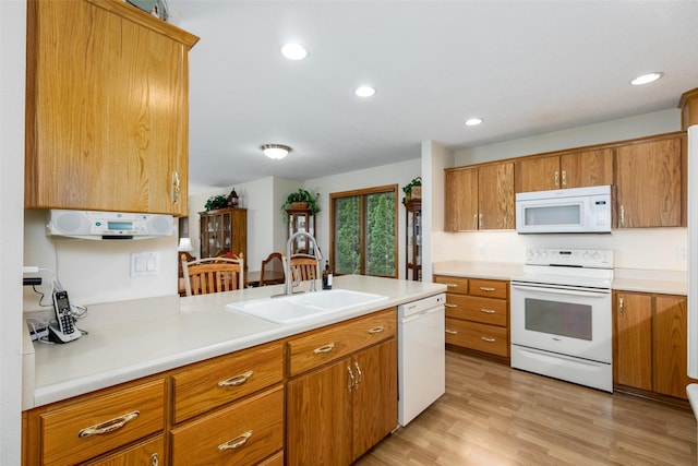 1412 Court St, Adel, IA 50003 - kitchen with white appliances, brown cabinetry, light countertops, light wood finished floors, and recessed lighting