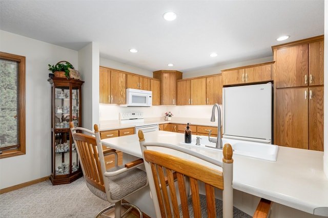 1412 Court St, Adel, IA 50003 - kitchen featuring white appliances, light countertops, recessed lighting, light colored carpet, and a breakfast bar area