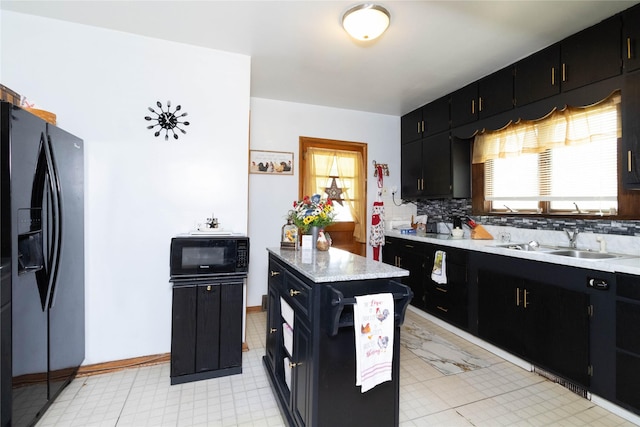 3851 E 25th St, Des Moines, IA 50317 - kitchen with black appliances, dark cabinets, and light countertops