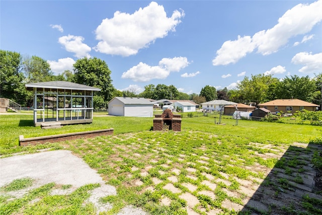 3851 E 25th St, Des Moines, IA 50317 - view of yard featuring a detached garage, an outbuilding, and a sunroom
