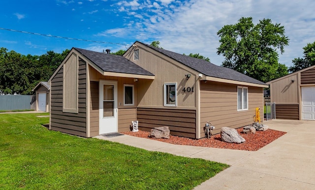 401 NW 50th Pl, Des Moines, IA 50313 - view of front of property featuring an outbuilding, a front yard, and a shingled roof