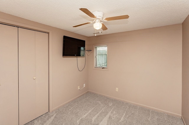 401 NW 50th Pl, Des Moines, IA 50313 - unfurnished bedroom featuring light carpet, a closet, a textured ceiling, and ceiling fan