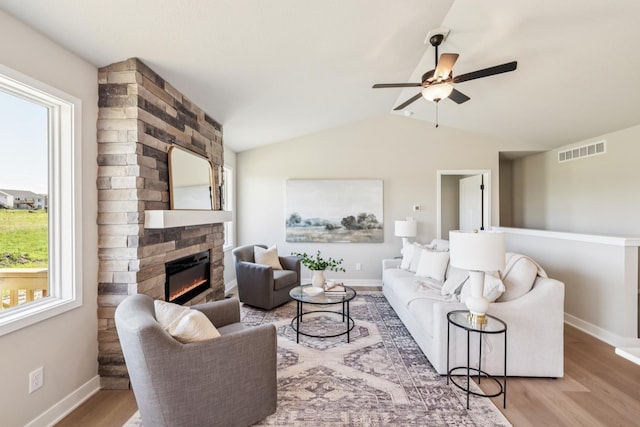 4422 NW Olivia Ln, Ankeny, IA 50023 - living area featuring a stone fireplace, ceiling fan, wood finished floors, and lofted ceiling