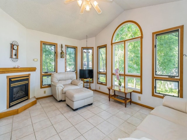 1907 Thornton Ct, Des Moines, IA 50320 - living room with ceiling fan, healthy amount of natural light, vaulted ceiling, light tile patterned floors, and a glass covered fireplace