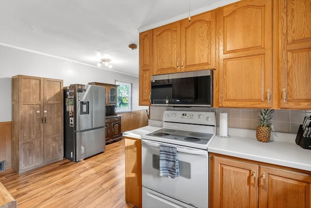 228 Hillside Ave, West Des Moines, IA 50265 - kitchen with appliances with stainless steel finishes, light wood-style flooring, backsplash, brown cabinetry, and ornamental molding