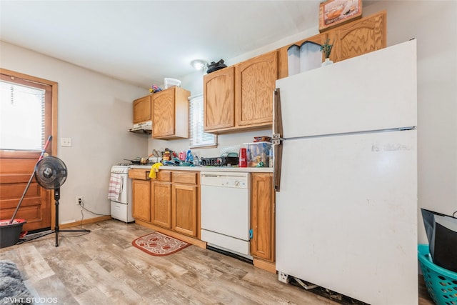4131 55th St, Des Moines, IA 50310 - kitchen with white appliances, light wood-type flooring, light countertops, and under cabinet range hood