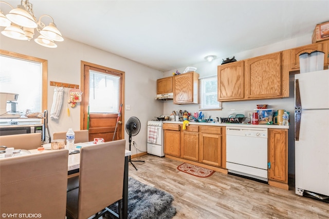 4131 55th St, Des Moines, IA 50310 - kitchen featuring white appliances, light wood-style floors, light countertops, under cabinet range hood, and pendant lighting