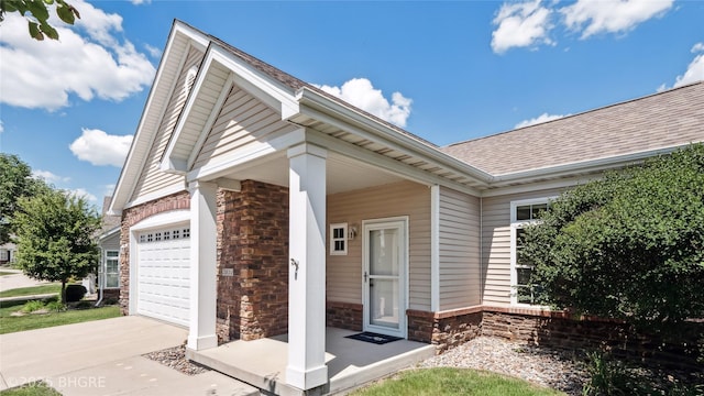 2811 SW Westview Ln, Ankeny, IA 50023 - entrance to property featuring stone siding, a shingled roof, concrete driveway, and an attached garage