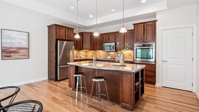 2811 SW Westview Ln, Ankeny, IA 50023 - kitchen featuring stainless steel appliances, light wood-style flooring, tasteful backsplash, hanging light fixtures, and recessed lighting