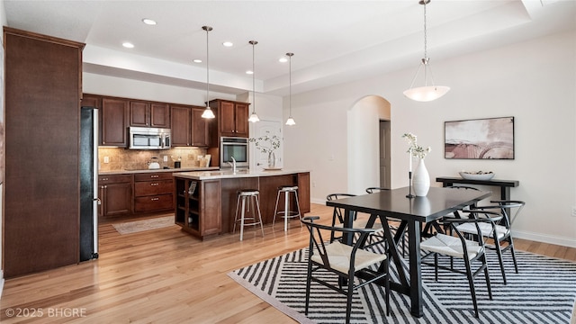 2811 SW Westview Ln, Ankeny, IA 50023 - dining area with arched walkways, light wood-style floors, and recessed lighting