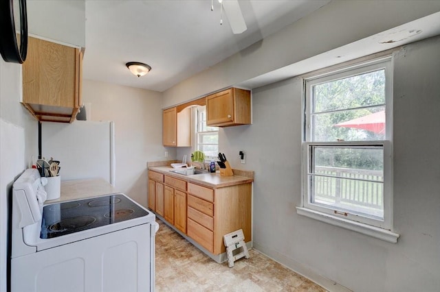 2721 E 16th St, Des Moines, IA 50316 - kitchen featuring white appliances, healthy amount of natural light, light countertops, and a ceiling fan