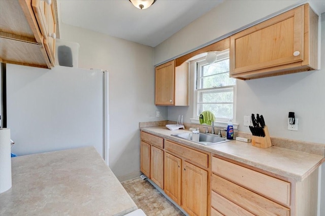 2721 E 16th St, Des Moines, IA 50316 - kitchen with light brown cabinets, light countertops, and freestanding refrigerator