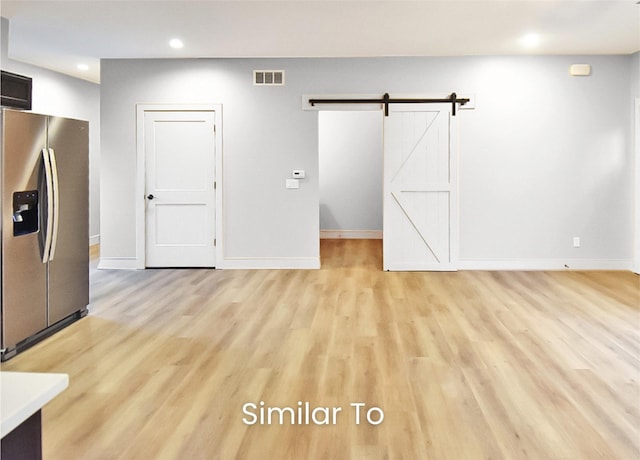 309 W Cherry St, Ogden, IA 50212 - unfurnished living room featuring recessed lighting, light wood-type flooring, and a barn door