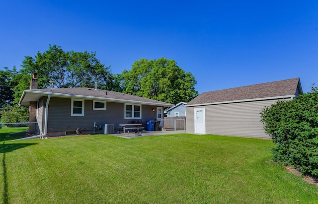 1022 Trisha Ave, Des Moines, IA 50313 - back of house with a chimney, a patio, and an outbuilding