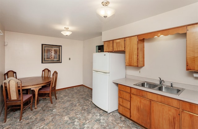 1022 Trisha Ave, Des Moines, IA 50313 - kitchen featuring freestanding refrigerator, light countertops, and brown cabinets