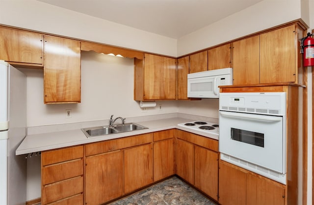 1022 Trisha Ave, Des Moines, IA 50313 - kitchen with white appliances, light countertops, stone finish floors, and brown cabinets