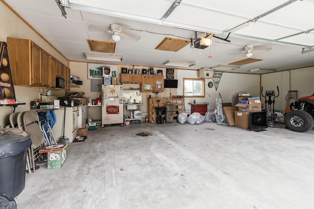 308 S 3rd St, Milo, IA 50166 - garage featuring a garage door opener, a workshop area, and freestanding refrigerator