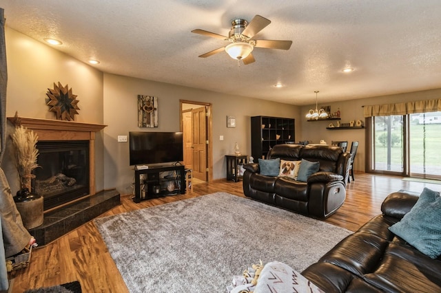 308 S 3rd St, Milo, IA 50166 - living room with a chandelier, a textured ceiling, ceiling fan, a glass covered fireplace, and recessed lighting
